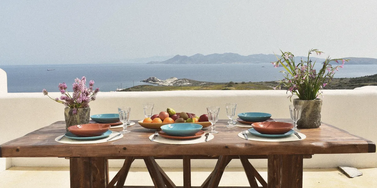 A long table on the terrace at Aegean Blue Houses with the Aegean beyond
