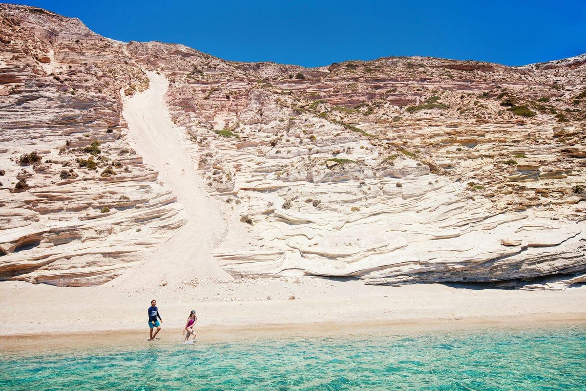 A quiet beach beneath the pale cliffs of Milos